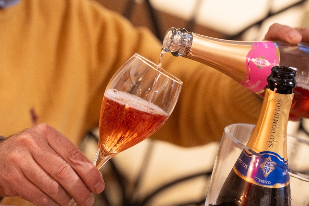 mano sirviendo un vino espumoso