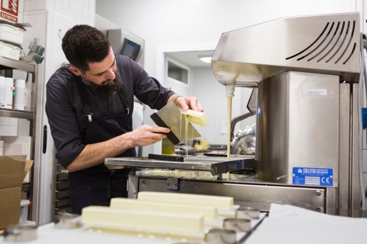 Trabajando el chocolate blanco en un molde para elaborar el turrón de pistacho.