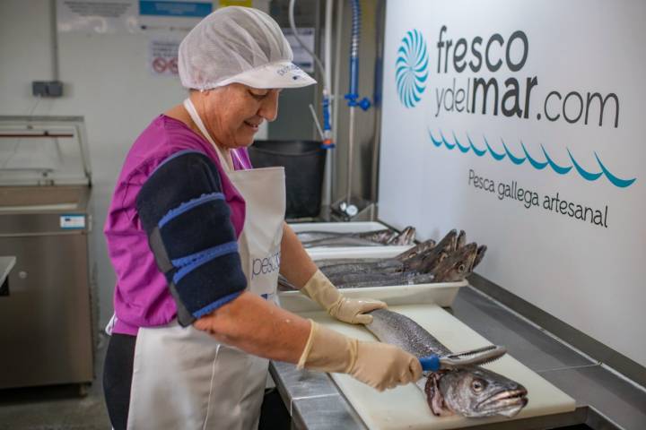 Pescadera trabajando sobre una merluza.