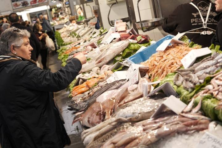 Señora comprando en puesto de pescado.