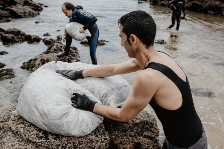 Sergio y Oscar, de Mar de Ardora, peleando con los pesados sacos de algas en las costas de Galicia.