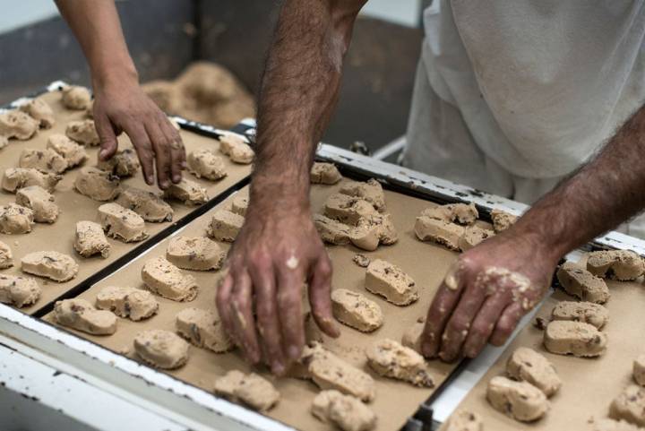 Los polvorones salen de la cortadora camino al horneado.