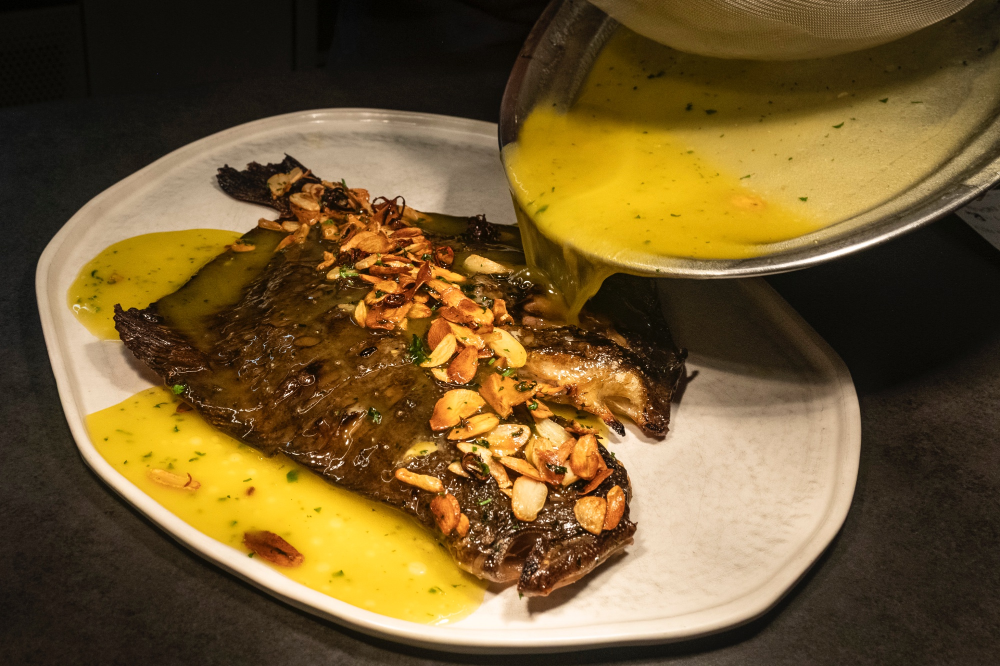 Rodaballo a la parrilla, con refrito de ajo, guindilla y perejil.