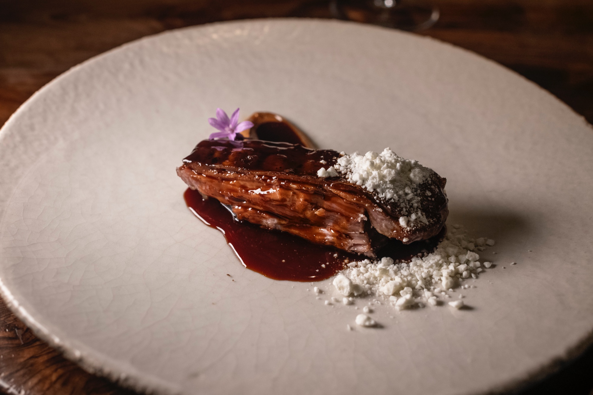 Cuello de cordero con praline de ajo asado, queso feta y fondo de cordero.