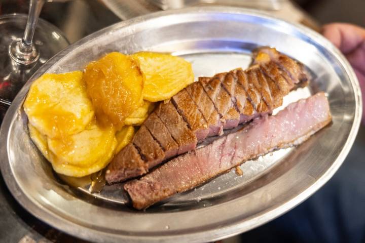 Una bandeja de metal con ventresca de atún y patatas fritas.