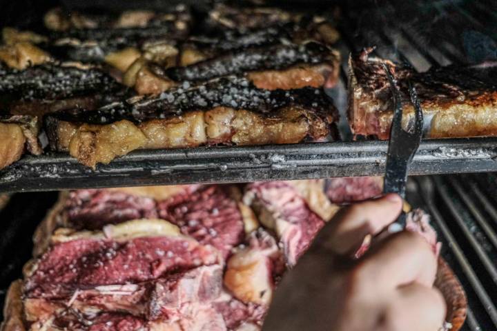 Parrilla con chuletas crudas y ya listas para salir