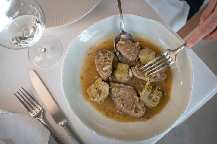 Guiso de mormo de atún de almadraba encebollado con alcachofay piñones.