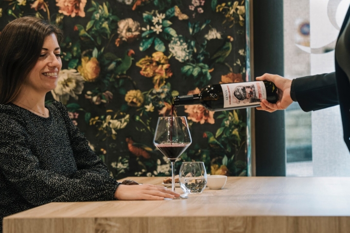 Una comensal con una copa de vino en el restaurante