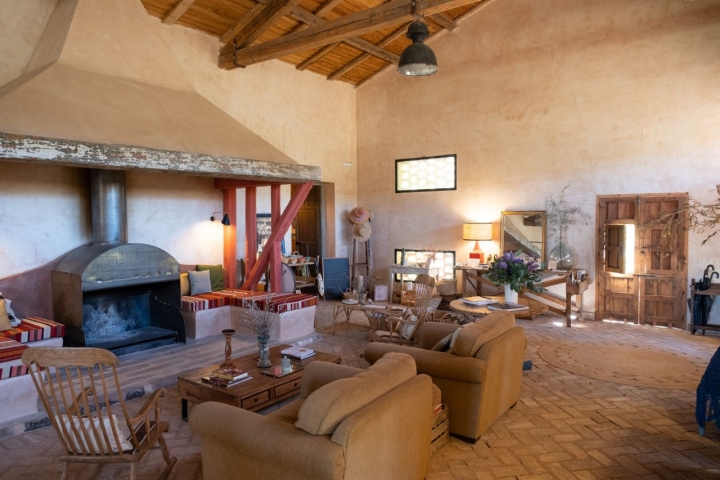 Una chimenea con sus sillones y asientos alredor.