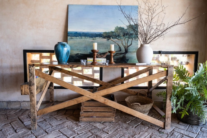 Una mesa con candelabros y un cuadro al fondo. 