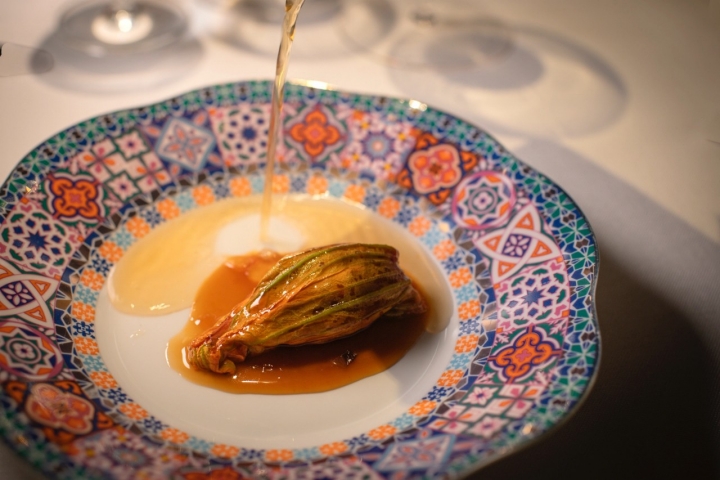 Flor de calabacín rellena de pisto manchego con caldo de agua de tomate picante. 