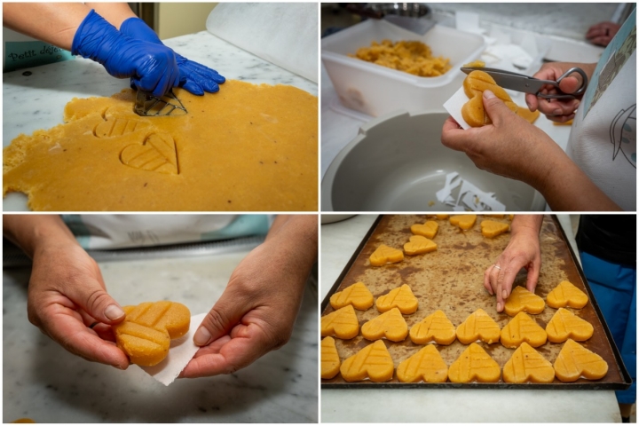 Dando forma una a una a las obleas de los corazones.  