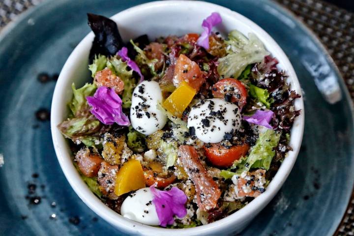 La ensalada de salmón de uga, con lechuga, tomate cherry, requesón, aceitunas y millo tostado