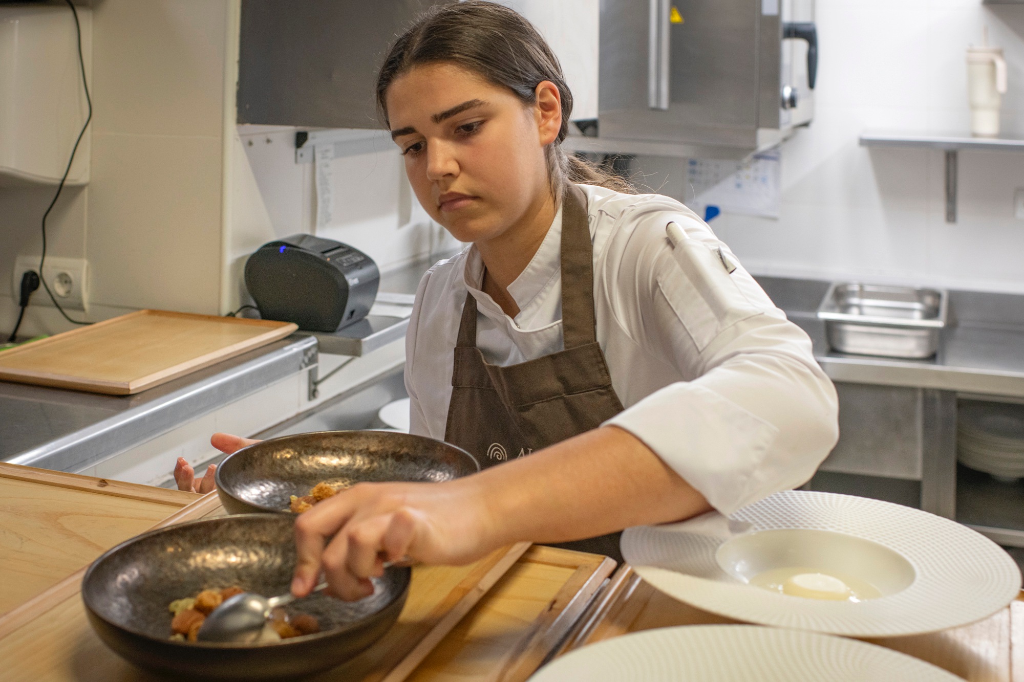 Elena, repostera, emplatando el plato de cacao calabaza y almendra.