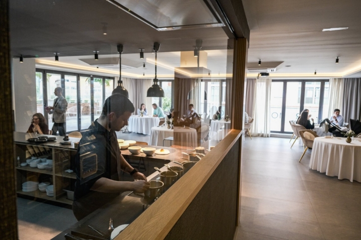 Sala y barra de Dromo vistos a través de una cristalera.