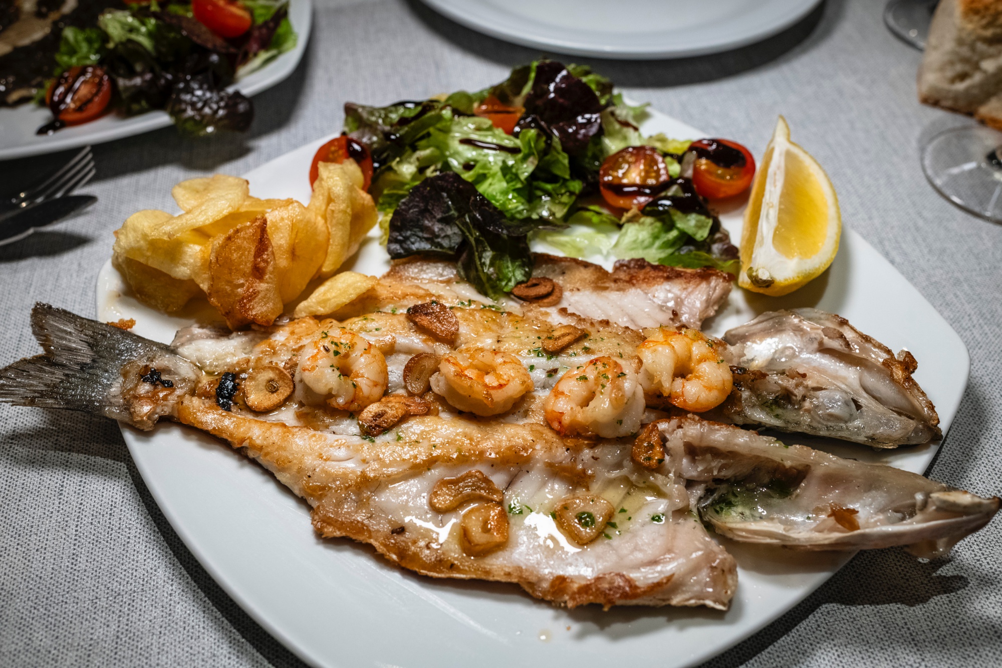 Lubina al horno con gambas y ajos.