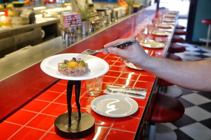 El steak tartar con patata crujiente y parmesano te lo acercan en unas piernas.