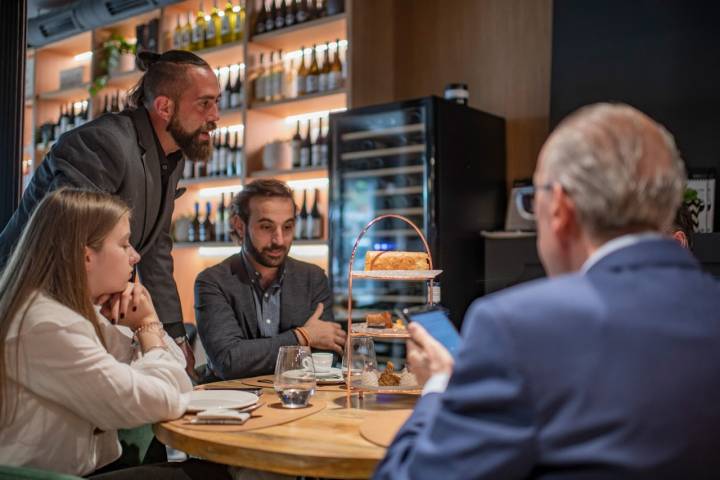 Miguel explica los postres, entre los que no falta la torrija, a un grupo de comensales.