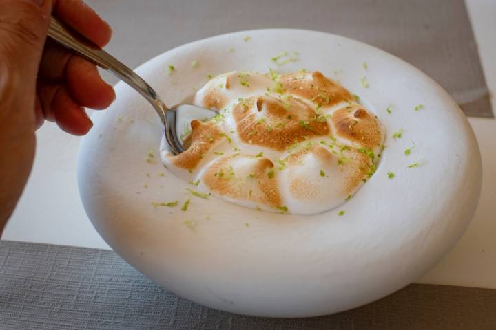 Tartaleta de limón con crumble y lima rayada por encima.