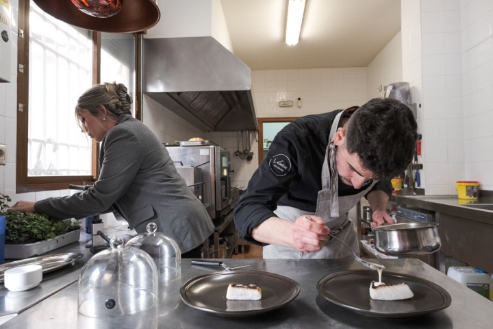 Ángel y Marta en la cocina emplatando la merluza. 