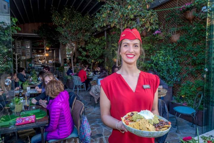 Elena nos enseña el plato de nachos con queso y guacamole que preparan para compartir.