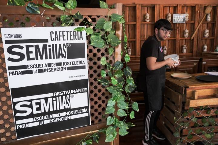 Un alumno coloca los platos en el restaurante.