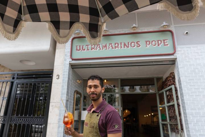 Un camarero con un cóctel en la puerta de Ultramarinos Pope (Valencia)