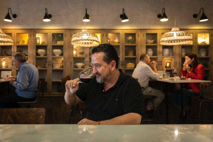 Un cliente tomando una copa de vino en Ultramarinos Pope (Valencia)
