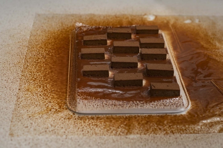 Jonathan utiliza un compresor para cubrir el turrón de chocolate. También se puede hacer con un baño tipo bombón.