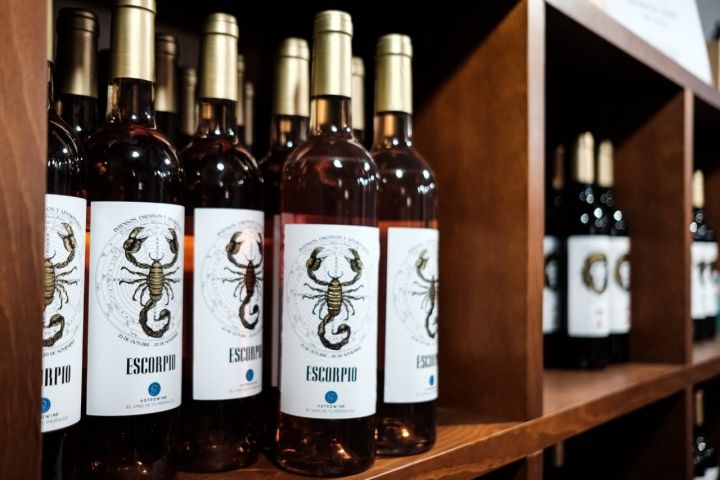 En una estantería, botellas de vino de Escorpio.