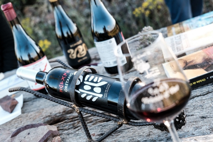 El vino Oretano sobre la mesa rodeado de libros y otras botellas.