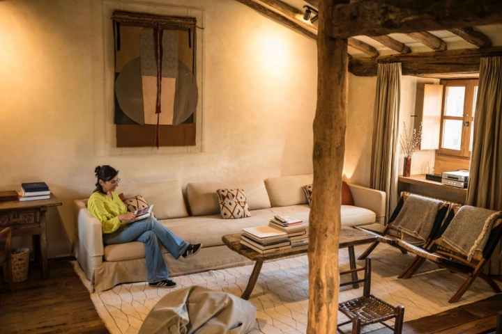 Una mujer lee en el salón de la cabaña más grande, Arce. Una mujer lee en el salón de la cabaña más grande, Arce.