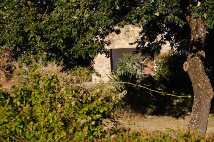 Uno de los edificios del hotel rural escondido entre los árboles.