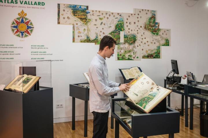 Manuel, dueño de la tienda, observando uno de los libros.