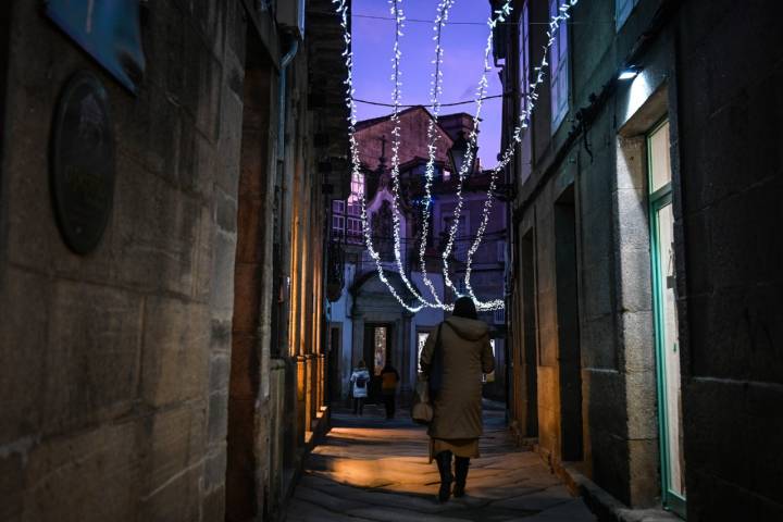 Una mujer pasea por el pueblo de noche.