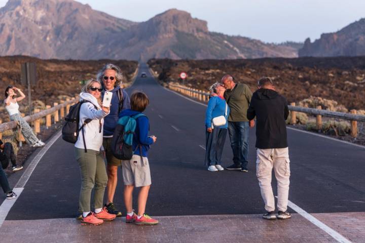 Turistas posan en una larga carretera que atraviesa el Parque Nacional del Teide