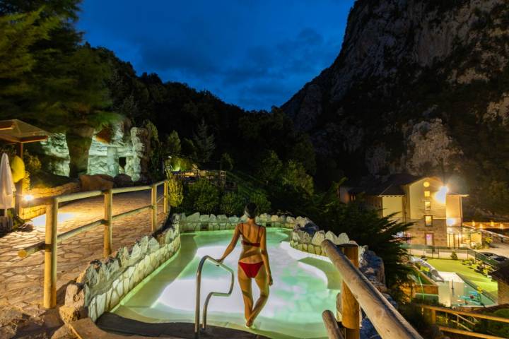 Chica bañándose en una piscina de balneario en plena noche.