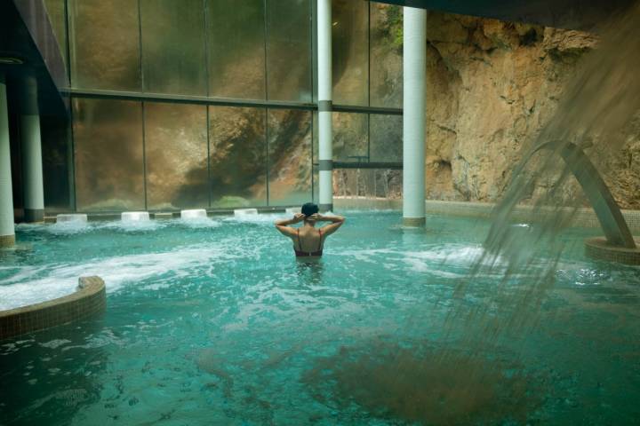 Chica bañándose en una piscina de balneario.