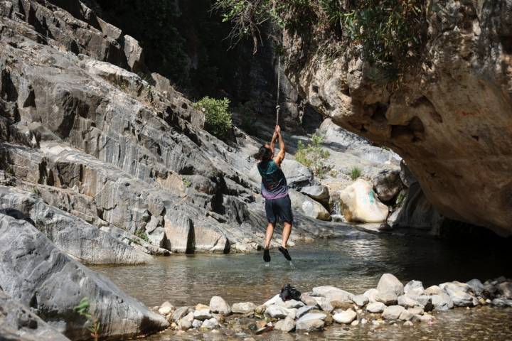 Un hombre juega en una cuerda sobre el agua.