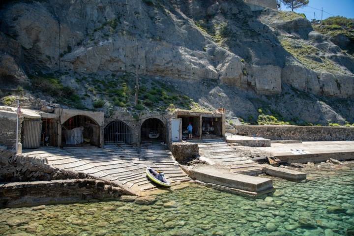 La cala de Banyalbufar se sitúa bajo un acantilado cubierto de pinos.