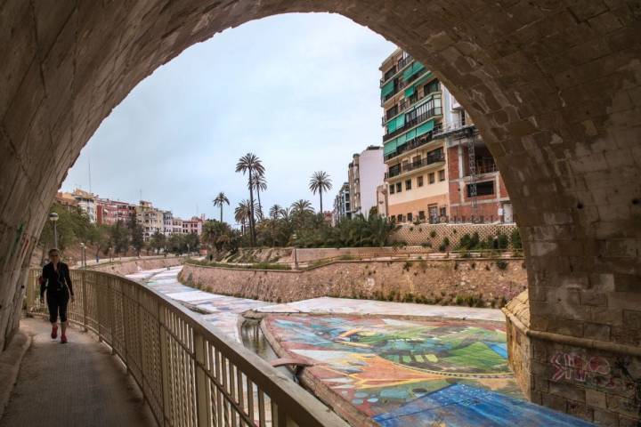 Una mujer anda a paso ligero por la ladera del río Vinapoló, en Elche, Alicante.