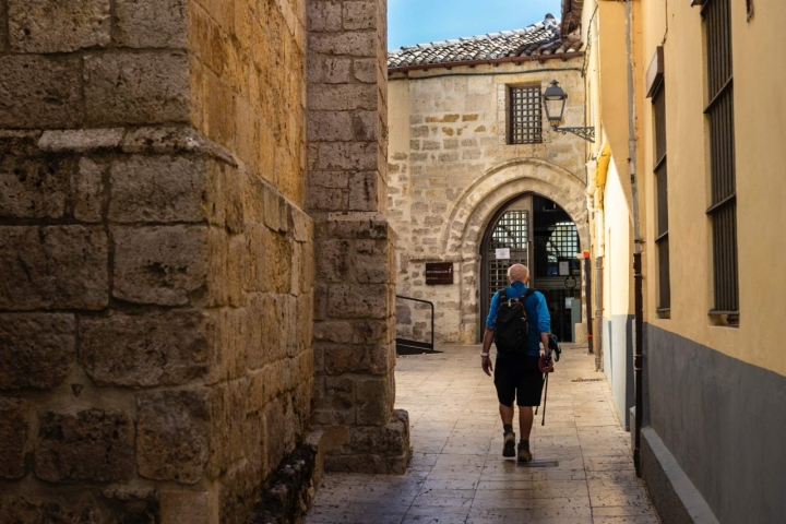 Un peregrino camina por las calles estrechas del municipio de Carrión de los Montes.