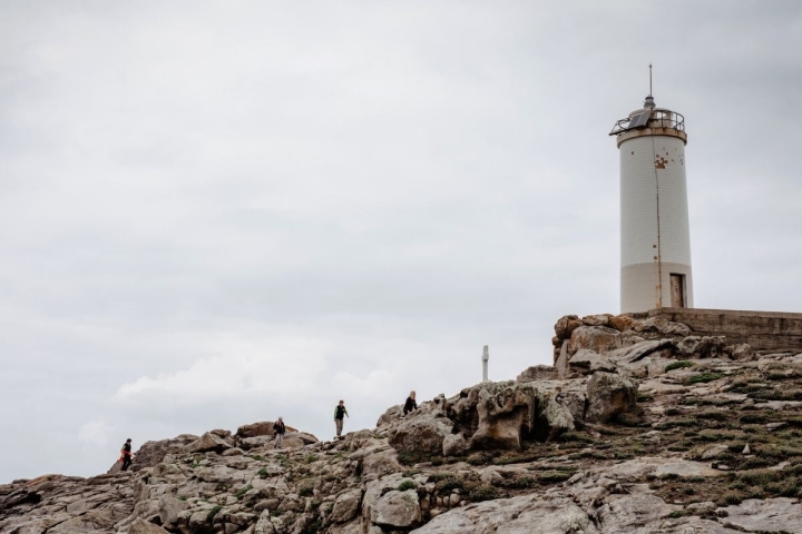 Un grupo de personas se acercan al faro O Camiño dos Faros (Costa da Morte, A Coruña).