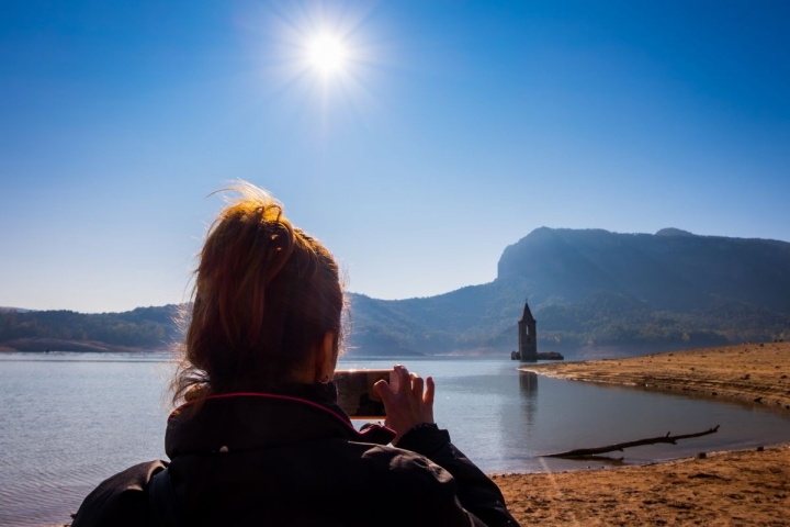 Fotografiando lo que queda al descubierto de la iglesia de San Román en el pantano de Sau, Cataluña. Foto: Shutterstock.